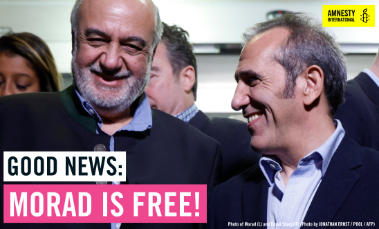 Morad stands in a group of people and smiles directly at the camera. Morad stands in a group of people and smiles directly at the camera.