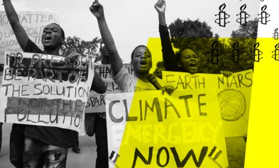 Three protesters holding a sign that says 'Climate Emergency Now' Three protesters holding a sign that says 'Climate Emergency Now'
