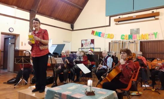 The conductor speaking in front of the orchestra The conductor speaking in front of the orchestra