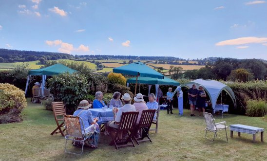 Tables, tents and people in a garden Tables, tents and people in a garden