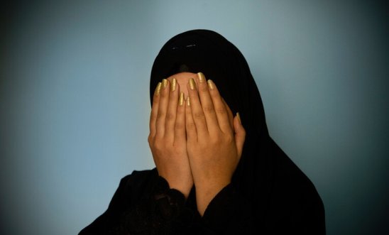 Woman in hijab holds her head in her hands with painted nails Woman in hijab holds her head in her hands with painted nails