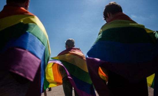 LGBT+ flag draped on people LGBT+ flag draped on people