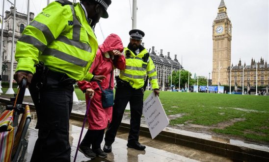 Protester being taken away by police