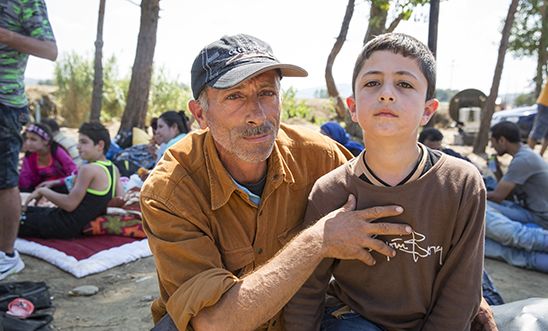 A Syrian man waits with his family of five at the Macedonia border