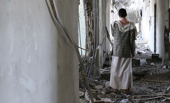 A man stands in rubble of destroyed building in Sa'ada.