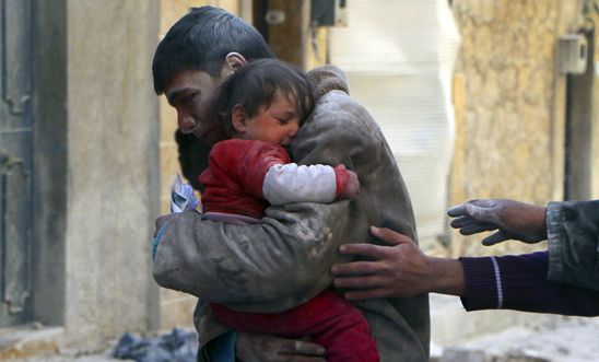 A boy holds his baby sister saved from rubble after an airstrike in Aleppo