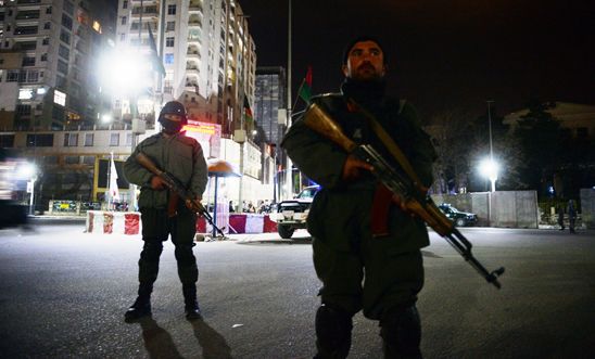 Afghan policemen stand guard in front of the Serena Hotel in Kabul on March 21 