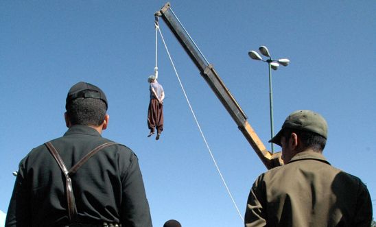 Iranian soldiers watch a man being hanged in Shiraz, south of Tehran, in 2007