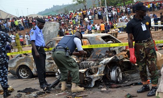 Nigerian security personnel inspect the site of a blast at Nyanya, Abuja