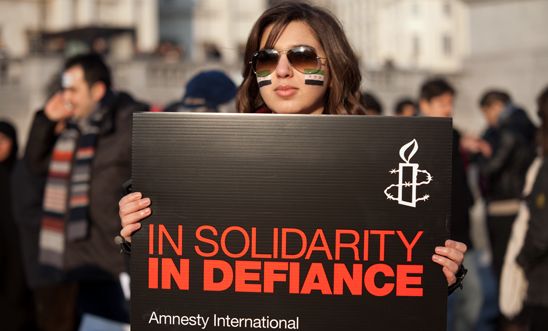 An activist holds a placard at our demonstration for solidarity with Syria, 2012