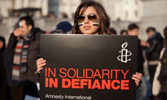 An activist holds a placard at our demonstration for solidarity with Syria, 2012 An activist holds a placard at our demonstration for solidarity with Syria, 2012