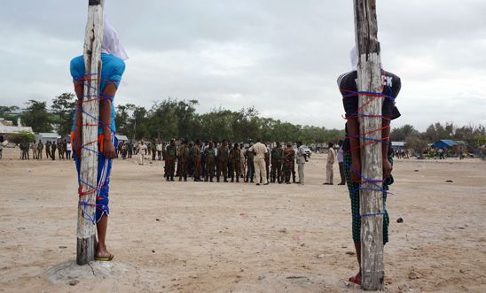 Two Somalis are tied to stakes as they await execution by firing squad