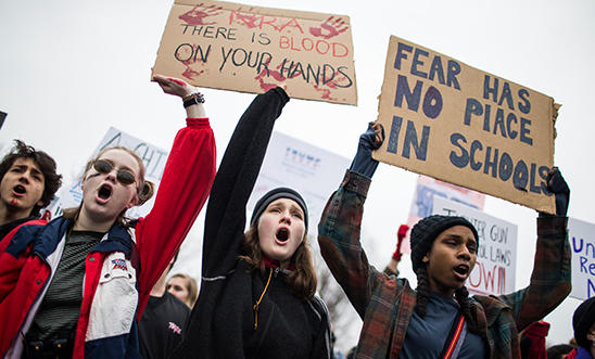 Young people with placards protesting for gun reform Young people with placards protesting for gun reform