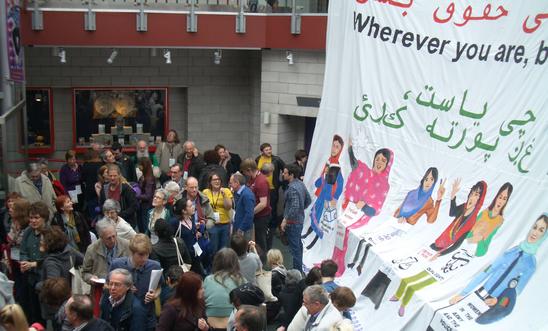 Large banner of women's rights in Afghanistan with conference delegates Large banner of women's rights in Afghanistan with conference delegates