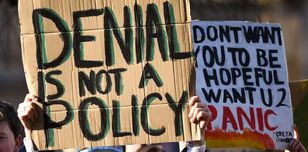 Young protestors hold up placards: denial is not a policy