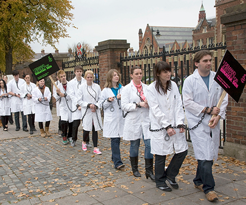 People protesting in white coats with Amnesty placards