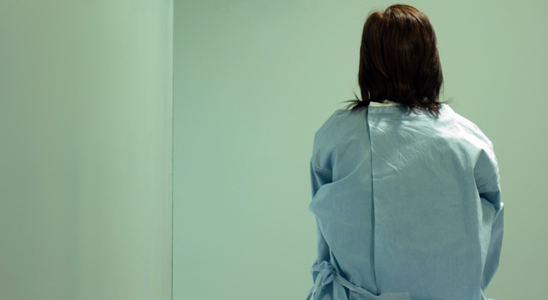 A woman sits on a hospital bed