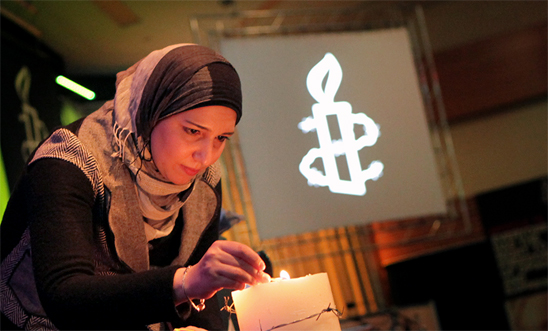 Reem Al Assil from the Syrian Non-Violence Movement lights the candle to open the AGM